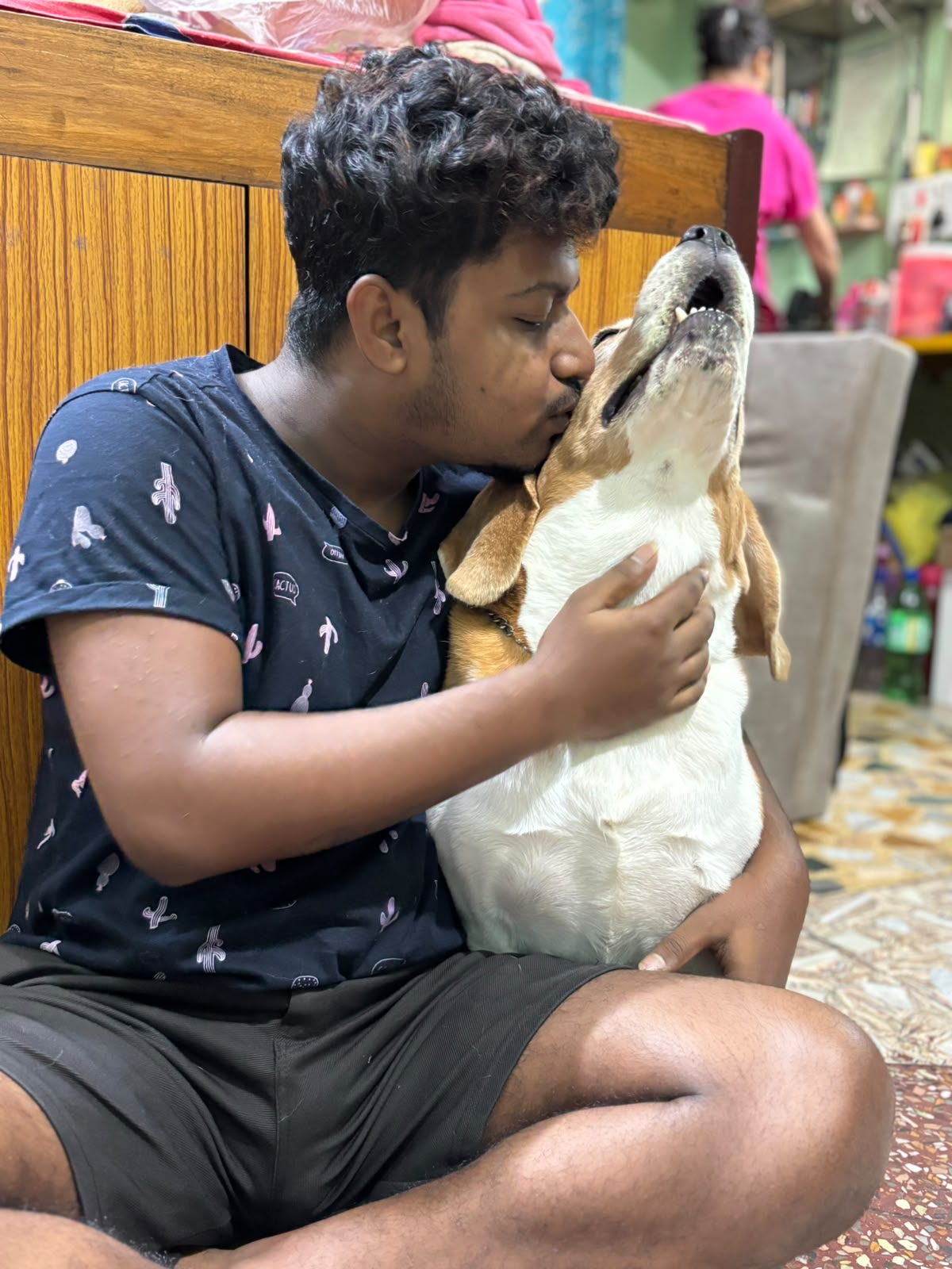 Pet parent kissing his Beagle